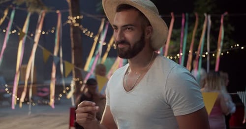 Smiling Man Wearing Straw Hat at Birthday Party