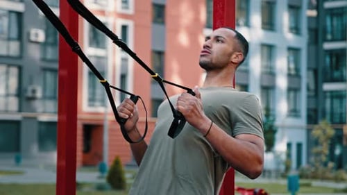 Man Exercising with Suspension Straps Outdoors