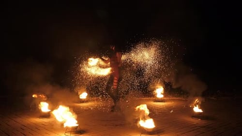 Woman Spins Fire Sparks in Dark Setting