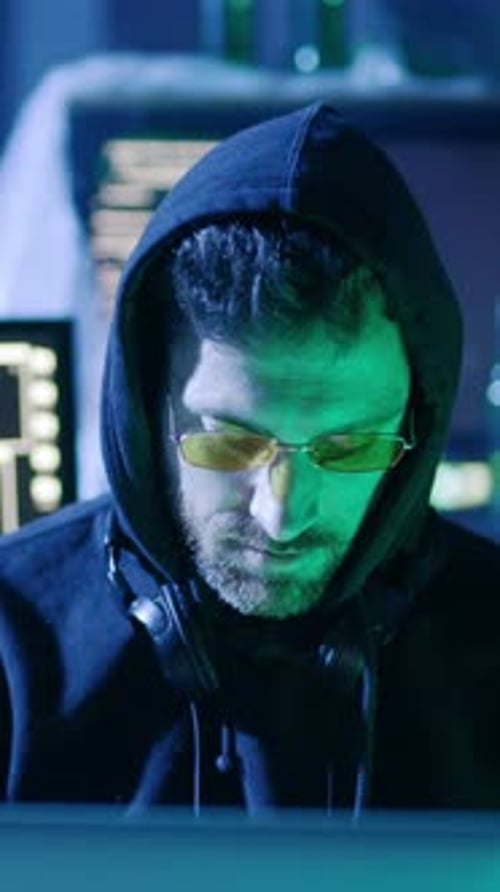 Man in Hoodie Works at Computer at Night
