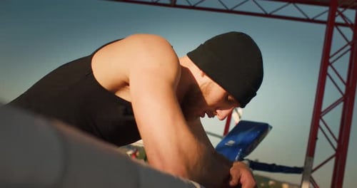 Boxer Leaning on Boxing Ring Rope Outside