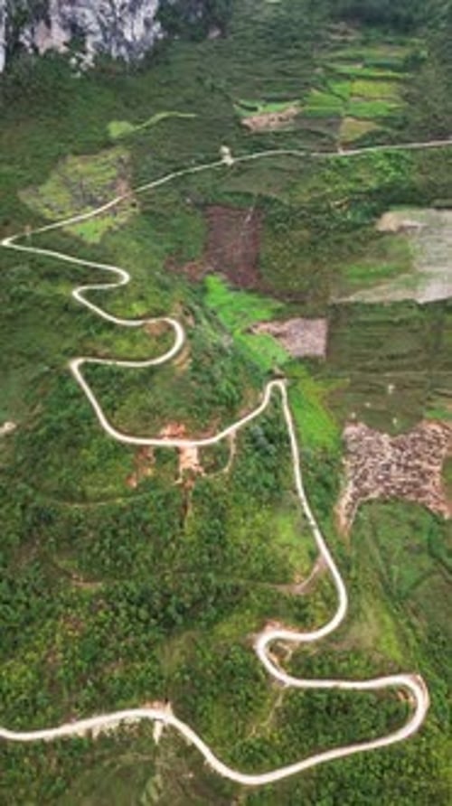 Mountain Road Cutting Across Terraced Hills and Dense Green Landscape in Northern Vietnam