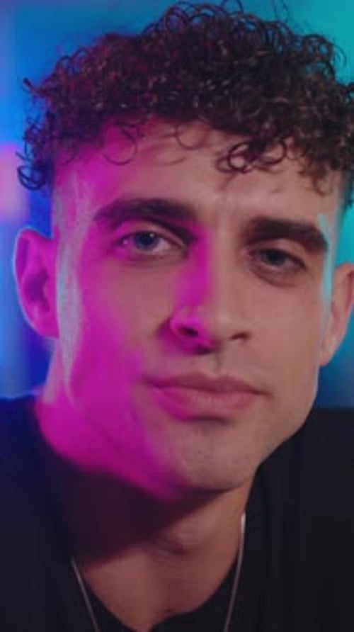 Un jeune homme souriant joyeusement dans une atmosphère lumineuse et colorée remplie d'énergie