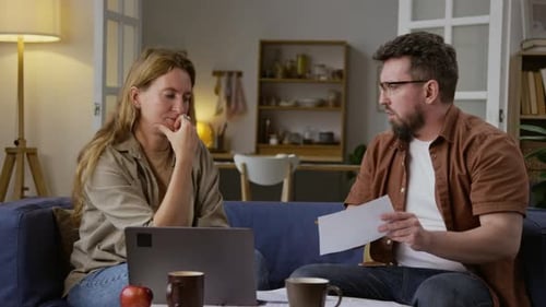 Couple Discussing Finances at Home on Couch