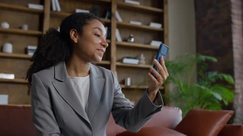 Smiling Woman Video Calling on Smartphone in Home