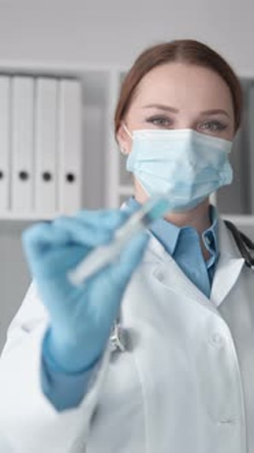 Young Adult Doctor with Syringe Preparing Injection