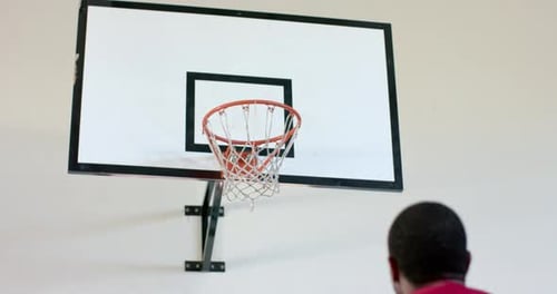 Man Shooting Orange Basketball Into Hoop