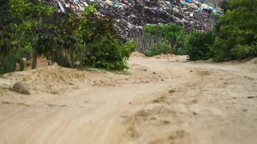 Kippaufnahme eines Stapels mit verschiedenen Arten von großen Müllkippen, Plastiktüten und brennendem Müll in der Nähe