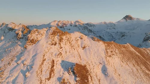 Mont Noble Snowy Summit Sunlit During Golden Hour in Valais, Switzerland. - aerial ascend
