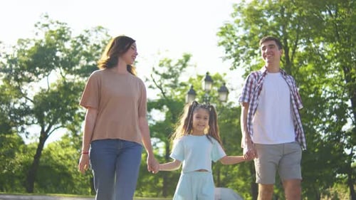 A Family Walks Happily Together in a Summer Park Enjoying the Outdoor Stroll Reflecting Joy Bonding