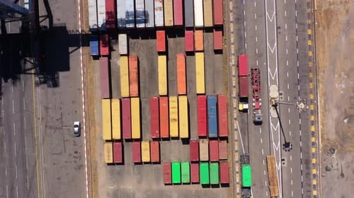 Luftbild über Reihen von Schiffscontainern und LKWs beim Laden
