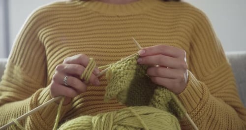 Woman Knitting with Green Yarn Close Up