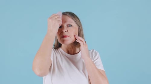 Woman Massaging Face with Gua Sha Tool
