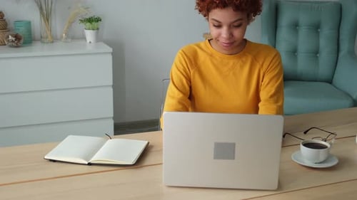 African American Girl Using Laptop at Home Office Looking at Screen Typing Chatting Reading Writing