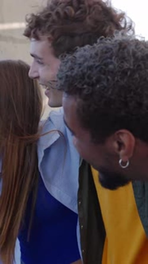 Grupo feliz de jovens se abraçando rindo ao ar livre