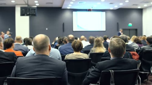 Audience Attending Corporate Conference in Large Room