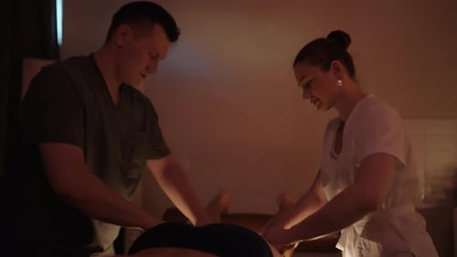 Two Therapists Giving Leg Massage in Bright Room