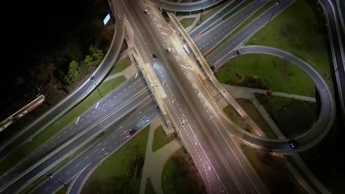 Drone footage of long-haul semi-trailers driving along a busy highway at night in rural Poland in th