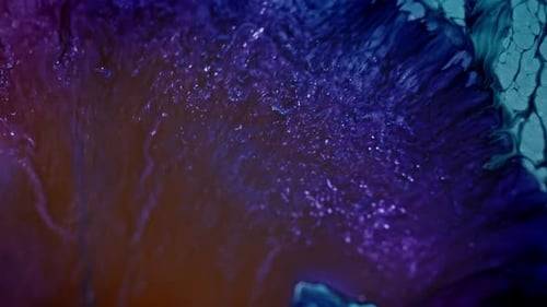 Vibrant blue and purple ink swirling in water, abstract background
