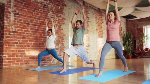 Group of people doing yoga poses on yoga mats