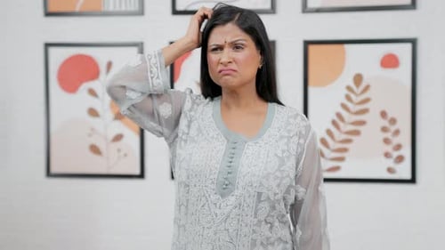 Woman Ponders with Confused Expression Indoors