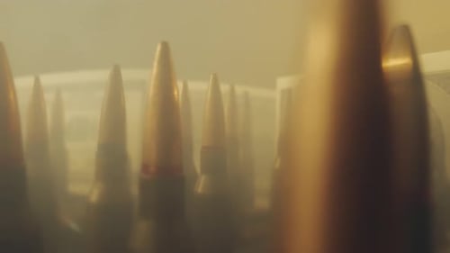 Cartuchos de rifle sobre el fondo de billetes de un dólar en nubes de humo de cerca El concepto del