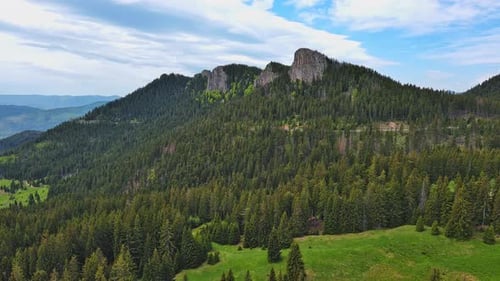 Road Passes and Meanders Among Hills Covered with Forests Against the Background of an Cloudy Sky