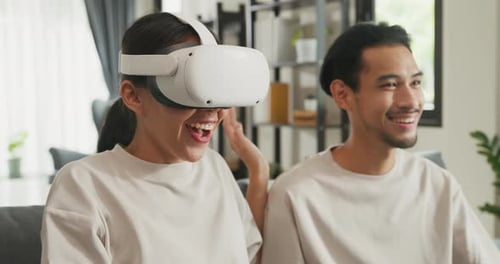 Woman Experiencing Virtual Reality Headset with Man Using Tablet