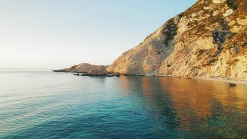 Golden sunlight touches seaside cliffs and sea waters in summer Kefalonia Greece