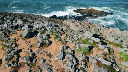 Beautiful Sunny Rocky Coast Cinematic Aerial View. Blue Foamy Ocean Waves Crashing