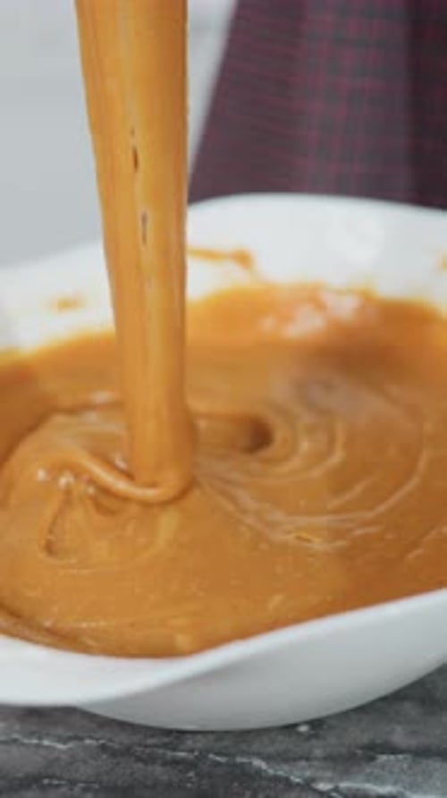 Golden-Brown Batter Being Whisked in White Bowl Indoors