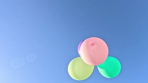 Pastel Balloons Floating Upward Into a Blue Sky