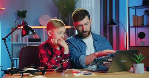 Father and Son Examining Drone Circuit Board