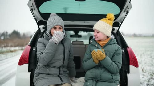 Mother and Teenager Drink Hot Beverage in Winter