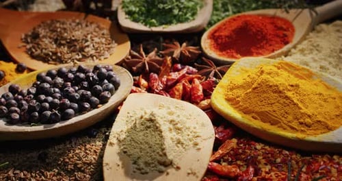 Close -up of a nice composition of spices and spoons on a turning base on bench. Concept: Food, tr