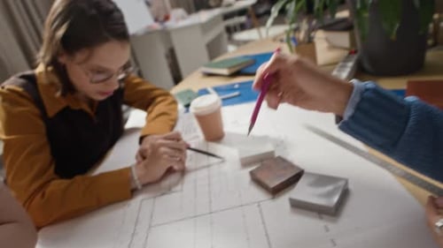 Diverse Architecture Team Reviewing Paper Building Plan in Modern Office