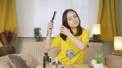 Young woman combing her hair. Hair care.