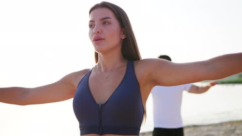 Young Couple Exercising on a Sunny Beach