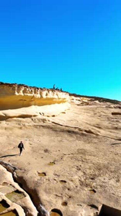 Tourists walk near the Xlendi Tower in Gozo Island, Malta.