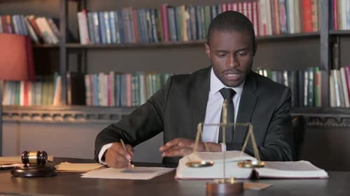 Professional Lawyer Studying Law Books and Taking Notes