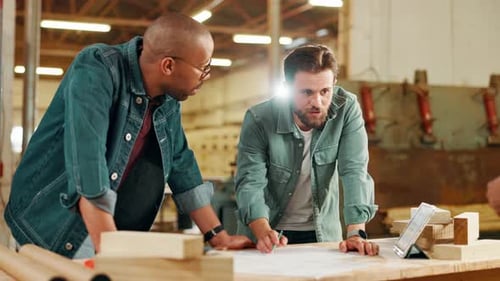 Men, carpenter and talk with blueprint in workshop for ideas, manufacturing and furniture process