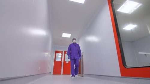 Pharmacist in Uniform Moving in Laboratory Corridor. Steadycam of Scientist Walking