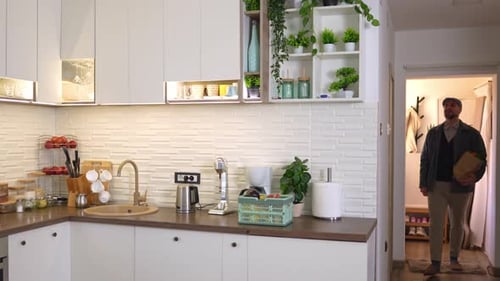 Man Arrives Home with Groceries in Modern Kitchen