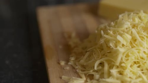 Aufschlussreicher Schuss Käse, gerieben auf einem Schneidebrett