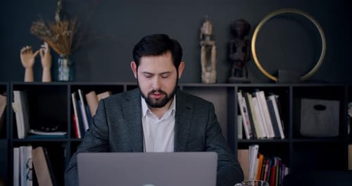 Portrait of Young Smart Handsome Caucasian Freelancer Businessman Using Laptop to Work From Home on