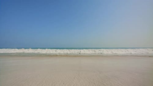 Approaching blue sea, Ocean beach waves then water slides under the camera. 4k footage