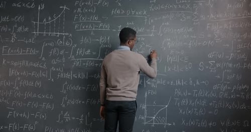 Smart African American Person Writing Mathematics Formula on Chalkboard Working at Science Research
