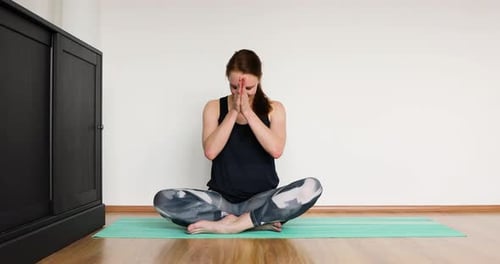 Woman Practicing Yoga on Mat Indoors