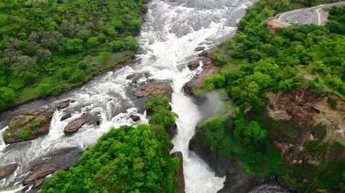 Aerial View Of Rocky Cascade Overhead Perspective Of Waterfall With Surrounding Greenery And Mist