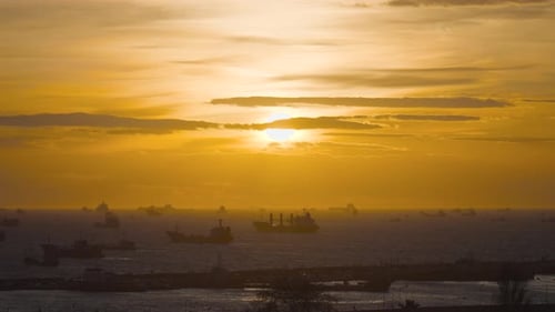 Navires de charge naviguant au coucher du soleil doré